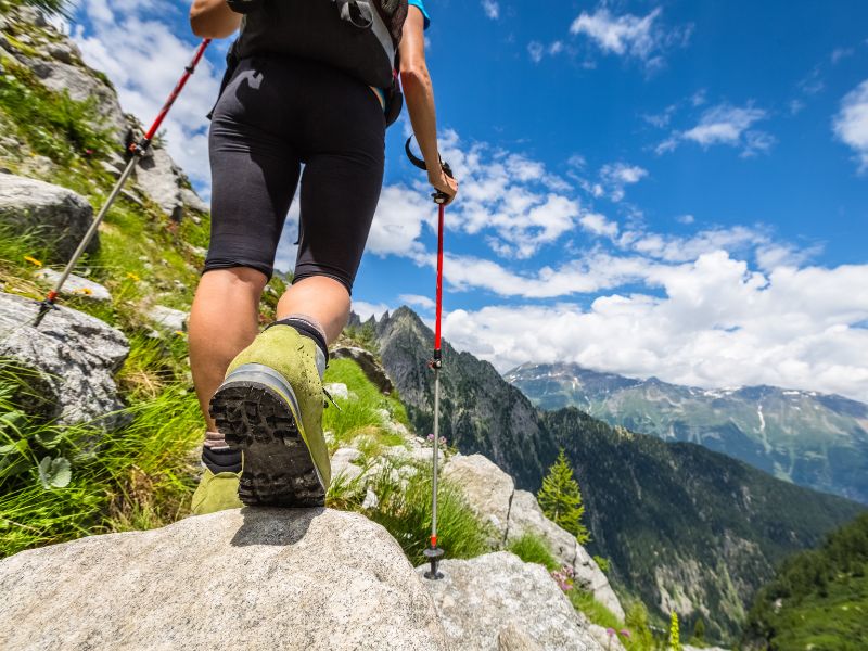 Randonneur en montagne avec des chaussures de randonnée et des bâtons de marche